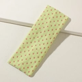 Detail eines limettengrünen Yoga-Stirnbands mit rosa Punkten auf weißem Hintergrund - Gelbgrün