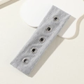 Graues elastisches Strickstirnband mit fünf silbernen Metallösen auf hellem Hintergrund - Grau