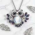 Macro shot of owl pendant featuring blue crystals and a central moonstone gemstone - Silver