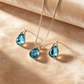 Elegant silver-toned bridal jewelry set featuring deep blue teardrop crystal necklace and earrings - Aquamarine