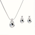 Macro shot of silver water drop necklace and earrings set with faceted blue crystals - White