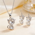 Detail shot of heart-shaped crystal cat pendant necklace and earrings jewelry set - Necklace + Earrings / White