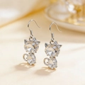 Cat-shaped crystal drop earrings featuring faceted clear stones and a tiny bow detail - Earrings / White