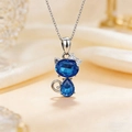 Cute silver cat necklace with two dark blue heart crystals on beige silk background - Necklace / Blue