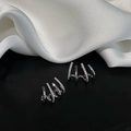 Minimalist S925 silver needle four-claw diamond curved stud earrings on silk background - Silver