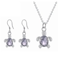 Detailed macro view of turtle jewelry set featuring oval purple crystal and silver metal - Purple