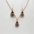 Close-up of gold-plated Christmas tree jewelry set with festive green and red enamel details - Simple Green Enamel Tree