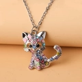 Macro shot of silver cat necklace pendant encrusted with colorful rhinestones and pink bow - Necklace / Pink