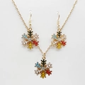 Macro view of gold snowflake necklace and earrings set with colorful enamel and crystals - Elegant White Snowflake