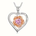 Detail of heart necklace with rose gold flower and I love you engraving on silver band - October-Pink