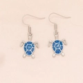 Blue fire opal turtle drop earrings with silver plating for women on pink background - Blue