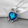 Niedliche Eulen-Halskette mit blauem Herzkristall auf elegantem weißem Seidenstoff - Silber & Blau