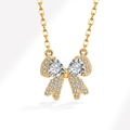 Gouden ketting met strikhanger voorzien van driehoekige stenen en zirkonia pavé - 925 zilver / 18K Goud