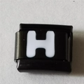 Close-up van zwart roestvrijstalen Italiaanse armbandbedel met witte letter H - Zwart En Wit Letter H (1222)