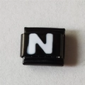 Detail van een vierkante modulaire bedel met witte letter N op zwarte lak - Zwart En Wit Letter N (1228)