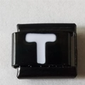 Detail van een vierkante zwarte roestvrijstalen bedel met witte letter T voor DIY-armbanden - Zwart En Wit Letter T (1234)