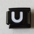 Macro-detail van Italiaanse bedel van roestvrij staal met witte letter U op zwarte basis - Zwart En Wit Letter U (1235)