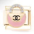 Makroansicht des goldenen Handtaschen-Anhängers mit rosa Emaille und Kristallen für Armbänder - Goldene Rosa Handtasche mit Doppel-C Logo