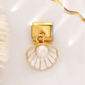 Detail of gold seashell Italian charm with white enamel and pearl on a coral background - Shell Pearl Style / White Pearl Shell Gold Charm