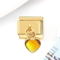 Vue macro d'un pendentif cœur en acier inoxydable doré de 9mm avec gemme jaune - Cœur Orange Brun