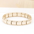 Dettaglio macro di una maglia per bracciale italiano modulare dorato con lettera T incisa - Lettera T