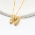 Macro shot of gold bubble letter M necklace pendant paved with shiny zircons - 925 Silver / Gold (Initial M)