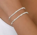 Nahaufnahme gestapelter silberner Glitzerarmbänder mit Mikro-Pavé-Kristallen am Handgelenk - Armband / Silber