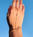 Detail of gold hand chain bracelet featuring rainbow zircons against a clear blue sky - Colorful Stones Style (Gold E)