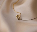 Gros plan d'anneaux entrelacés or et argent sur un tissu luxueux en satin champagne - Bicolore Or et Argent