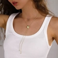 Collar lariat dorado en Y con pasador ovalado y colgante de sombrero en una modelo - Collar Lariat En Y Con Deslizador Ovalado / Dorado