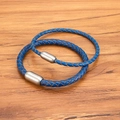 Geflochtene Lederarmbänder in Blau mit Edelstahl-Magnetverschluss auf Holzoberfläche - Blau Silber