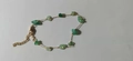 Detailed macro view of irregular green natural stone fragments on a gold chain bracelet - Green Stone Bracelet
