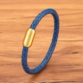 Königsblaues geflochtenes Lederarmband mit goldenem Magnetverschluss auf einer Holzoberfläche - Blau Goldene Schnalle