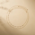 Detail of layered gold chains with round zircon stones and polished metal discs - Gold + Clear