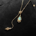 Makro-Detail des Opal-Anhängers in Tropfenform mit Goldblatt-Akzent auf Schwarz - Y-Form Blatt Verstellbare Kette Set