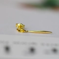 Macro shot of minimalist gold drop earring featuring a shuttle-shaped yellow gemstone - Natural Citrine / Citrine