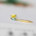 Macro shot of gold leaf earrings with blue marquise cut crystal and smooth pendant - Blue Topaz
