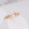 Detailed shot of oval pink crystal gemstone in rose gold setting with zircon accents - US 5 / Rose Quartz