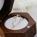 Detailed close-up of S925 silver 14K gold plated ring with blue topaz in a wooden box - US 5 / Sky Blue Topaz Ring
