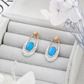 Nahaufnahme der blauen Opal-Ohrhänger mit zweifarbigen Gold- und Silberelementen in Box - Einheitsgröße / 925 Silberstecker / Passende Ohrringe