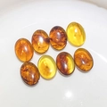 Cabochons ovales en ambre synthétique poli avec texture fluide sur fond blanc pur - Pierres Décoratives en Ambre Teintes Variées