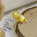 Macro shot of vintage rectangular yellow amber ring with silver bird and gold floral band - US 6 / Ring