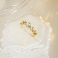 Close-up of a lace-style gold ring with oval light blue gemstone in a velvet jewelry box - Blue Topaz Vine Style (2927)