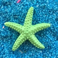 Green resin starfish ornament with detailed texture on blue sand for aquarium decor - 3cm Pitted Style / Green