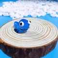 Macro shot of cute blue resin salamander figure on wood slice for micro landscape - Blue