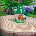 Detailed view of resin mushroom house figurine on wooden stump with fairy garden decor - Green