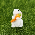 Miniature white rabbit resin figurine holding a carrot on green grass garden decor - Side Hugging Carrot (No.6)