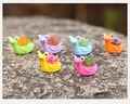 Close-up of six colorful resin snail figurines with succulent shells on natural rock surface - Six Color Combo