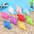 Miniature colorful resin seashells set for DIY crafts on a decorative sand beach - Conch