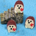 Lot de trois figurines hérissons en résine tenant des champignons sur sable bleu - Petit Hérisson